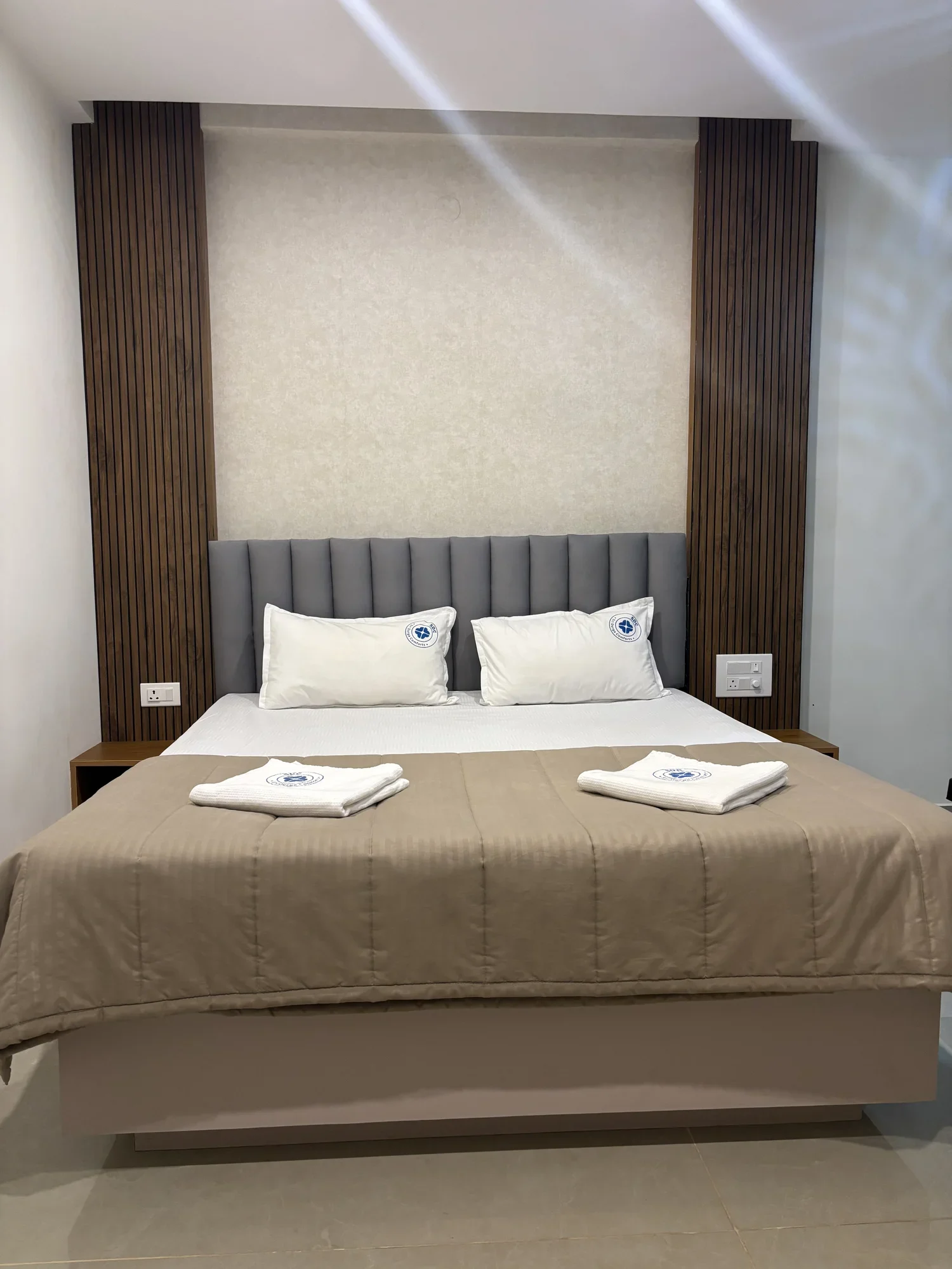 Double bedroom at Sri Durga Comforts with upholstered headboard, decorative fluting and crisp linens