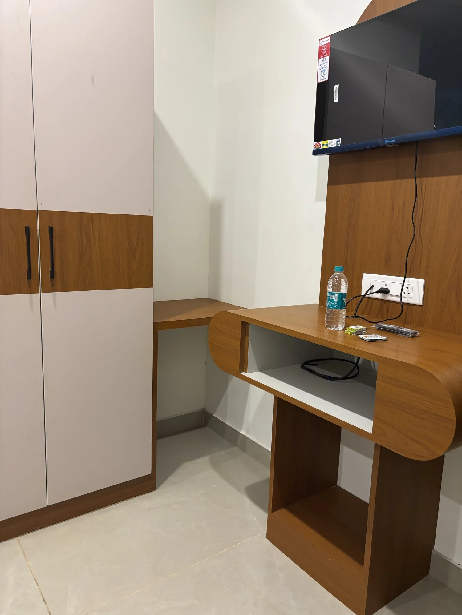 Room wardrobe, vanity mirror and wall mounted TV console at Sri Durga Comforts